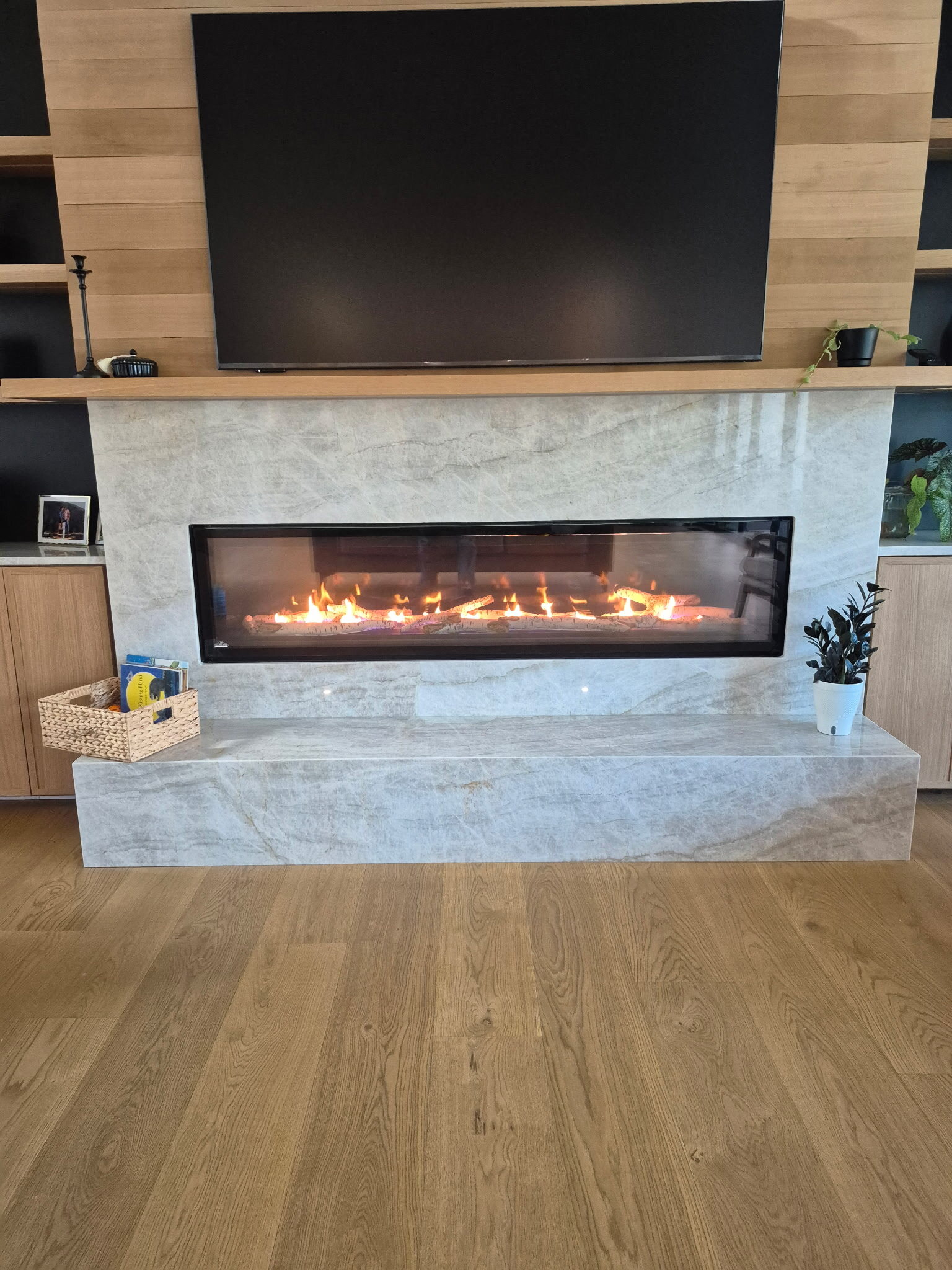 Linear gas fireplace with a stone surround installed by Central Air Solutions
